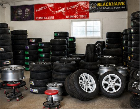 Inside the shop: shelves of tires and wheels under Kumho and Blackhawk banners
